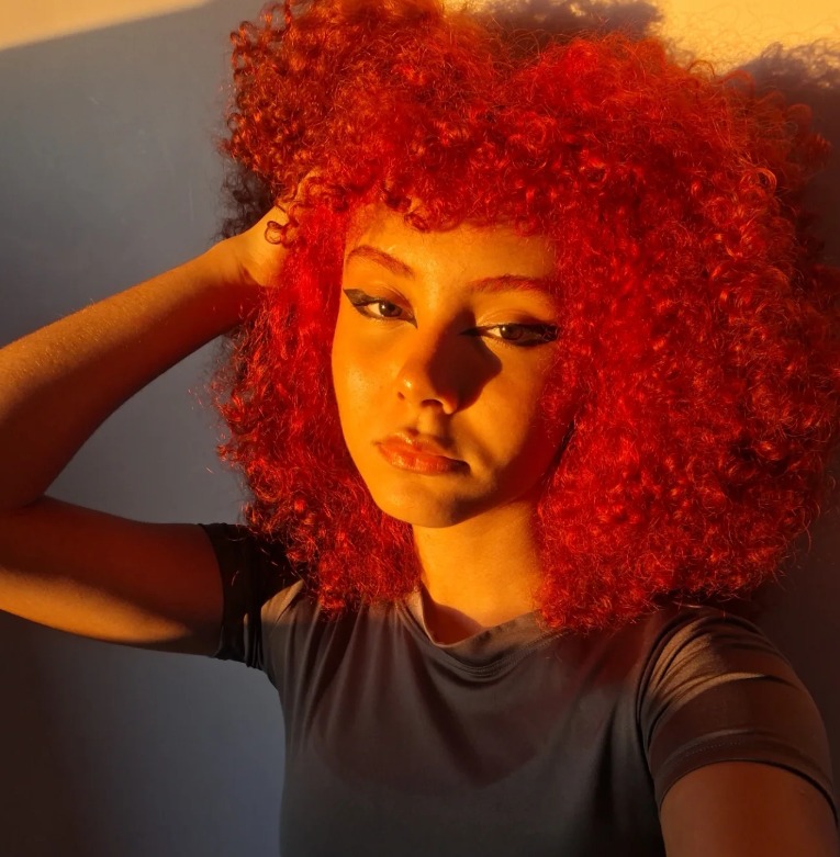 Emy com o braço atrás do cabelo
