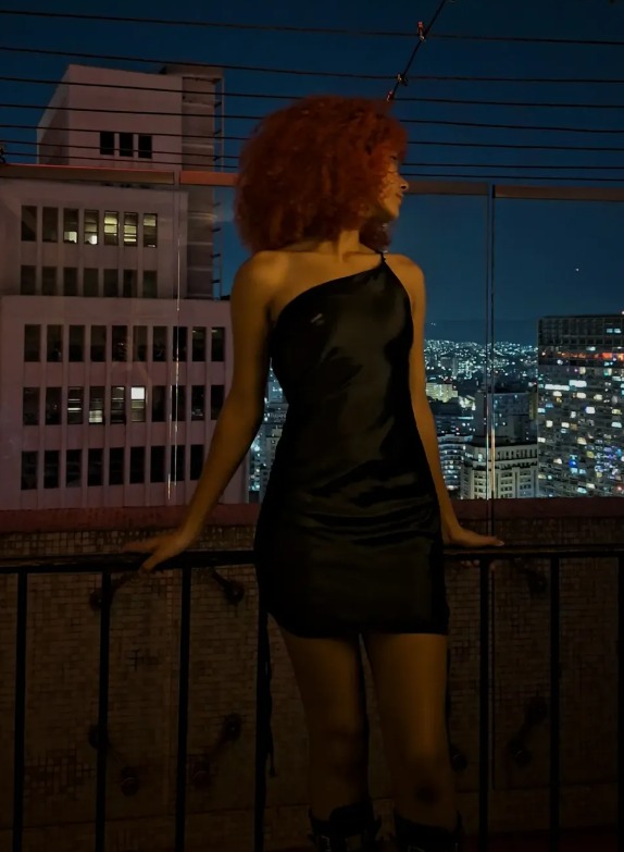 Emy de perfil contra a cidade